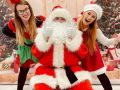 Zdjęcie przedstawia Świętego Mikołaja i dwie uśmiechnięte pomocnice